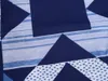 A close-up view of a blue and white patchwork fabric with geometric patterns. Produktbild-Vorschau