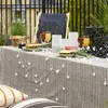 A table set for a party outdoors with fruit, drinks, and decorative lights. Náhled obrázku produktu