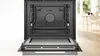 An open built-in oven with its door lowered, showing the interior. Produktbild-Vorschau