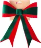 A decorative Christmas bow made of red and green velvet, attached to a cardboard backing. Produktbild-Vorschau