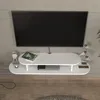 A white TV lowboard mounted on a textured gray wall, with a television above it. Podgląd zdjęcia produktu