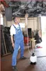 A mechanic is using a fluid transfer system under a car in a workshop. Náhľad obrázku produktu