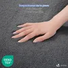 A hand resting on a textured gray surface, with text overlays and logos. Produktbild-Vorschau