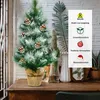 A small, decorated artificial Christmas tree sits on a wooden table, with decorative elements and text overlays on the right side of the image. Náhled obrázku produktu