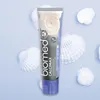 A tube of BIOMED CALCIMAX toothpaste is displayed on a light blue background surrounded by white seashells. Produktbild-Vorschau