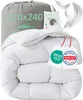 A white down comforter is folded and presented in a grey drawstring bag, with decorative elements like feathers and certification tags. Produktbild-Vorschau