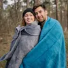 A couple wrapped in blankets in a forest. Produktbild-Vorschau