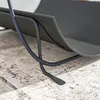 Close-up of the base of a dark gray firewood rack on a textured concrete floor. Produktbild-Vorschau