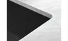 A close-up view of a black sink basin integrated into a white marble countertop. Podgląd zdjęcia produktu