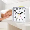 A person sleeping in bed with an alarm clock on a nightstand. Produktbild-Vorschau