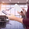 A person is charging a smartphone with a power bank in an airport lounge. Náhled obrázku produktu