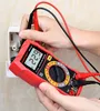 A person is using a red digital multimeter to measure voltage from a wall socket. Podgląd zdjęcia produktu