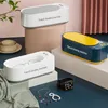Three ultrasonic cleaning machines are displayed on pedestals and a surface, with jewelry and a smartwatch nearby. Produktbild-Vorschau
