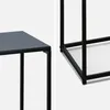 Close-up view of the corner of a black metal side table, showing the joinery and the edge of the tabletop. Produktbild-Vorschau