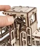 A close-up view of a wooden model of a self-propelled mower, with a person's finger interacting with the cabin. Podgląd zdjęcia produktu
