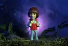 A toy figure of Will Byers from Stranger Things stands in a dark, misty forest setting. Podgląd zdjęcia produktu