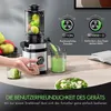 A person's hand is shown operating a silver and black juicer, with green juice being dispensed into a glass. There are also apples and other produce visible, along with a bowl of salad in the foreground. Text overlays describe the product's features. Produktbild-Vorschau