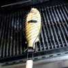 A whole fish is being grilled in a fish basket on a grill. Produktbild-Vorschau
