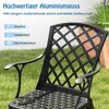 A black metal garden chair with a lattice back, set on a grassy lawn with some greenery and a wooden planter in the background. Podgląd zdjęcia produktu