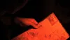 A person is looking at a city map illuminated by a red light. Náhľad obrázku produktu