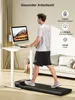A man is using a treadmill desk in a modern living room. Produktbild-Vorschau