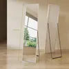 A full-length mirror is shown standing upright, with a second mirror behind it. The background is a plain wall and wooden floor, with a window showing greenery. Produktbild-Vorschau