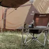 A camping scene with a tent, table, chair, and radio. Anteprima dell’immagine prodotto
