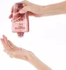 A hand is pouring a pink liquid from a clear bottle into another hand. Anteprima dell’immagine prodotto