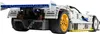 Rear view of a white Lego Technic Mazda 787B race car model with a large blue rear wing and yellow wheels. Produktbild-Vorschau