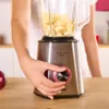 A person is using a blender to make a smoothie. Produktbild-Vorschau