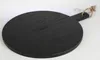 A black round cutting board with a handle and a rope loop is placed on a white surface. Anteprima dell’immagine prodotto