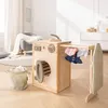 A wooden toy washing machine with accessories in a child's room. Produktbild-Vorschau