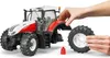 A person's hands are shown attaching a wheel to a toy tractor. Anteprima dell’immagine prodotto
