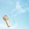 A hand fan blowing a large bubble against a light blue sky. Anteprima dell’immagine prodotto