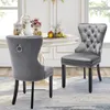 Two gray velvet dining chairs are placed around a white dining table in a well-lit room. Náhled obrázku produktu