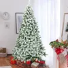 A flocked artificial Christmas tree with presents underneath, in a room with a clock and a fireplace with stockings. Anteprima dell’immagine prodotto