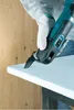 A person wearing gloves is using a multitool to cut a piece of white foam material. The background shows a wooden wall. Náhľad obrázku produktu