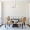 A dining table set with chairs, glasses, and plates, illuminated by a pendant light. Podgląd zdjęcia produktu