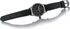 A close-up studio shot of a men's watch with a black leather strap and a gray metal casing, set against a white background with a reflection. Produktbild-Vorschau