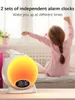 A young girl is stretching in bed next to a sunrise alarm clock. Náhled obrázku produktu