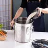 A person is pouring rice into a large stainless steel canister. Produktbild-Vorschau