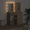A vanity table with a mirror and lights, a stool, and a plant in a pot. Podgląd zdjęcia produktu