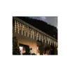 Icicle lights are installed on the roof of a house at dusk. Produktbild-Vorschau