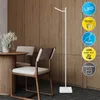 A modern interior scene with a white floor lamp next to a dining table and chairs. Produktbild-Vorschau