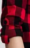 Close-up of a person's arm wearing a red and black checkered flannel shirt with rolled-up sleeves. Náhled obrázku produktu