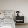 A bedroom scene with a bed and a nightstand. Voir les images du produit