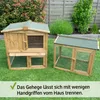 Two wooden animal enclosures are shown on a grassy lawn in front of a wooden fence and some bushes. Produktbild-Vorschau