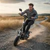 A man riding an electric scooter on a dirt road in a rural landscape during sunset. Náhled obrázku produktu