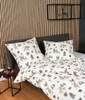 A bed with bedding featuring a deer and forest pattern, set against a slatted wooden wall. Produktbild-Vorschau