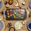 A table setting with a grill and food, suggesting a meal. Voir les images du produit